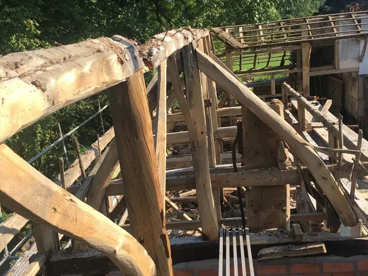 Blootgelegde houten kapconstructie tijdens een dakrenovatie