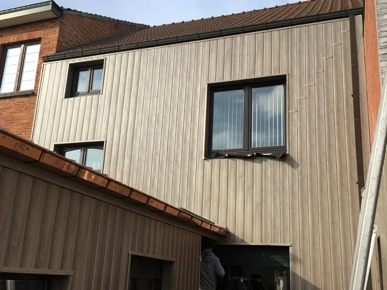 Gerenoveerd dak met nieuwe gevelbekleding in hout bij een woning